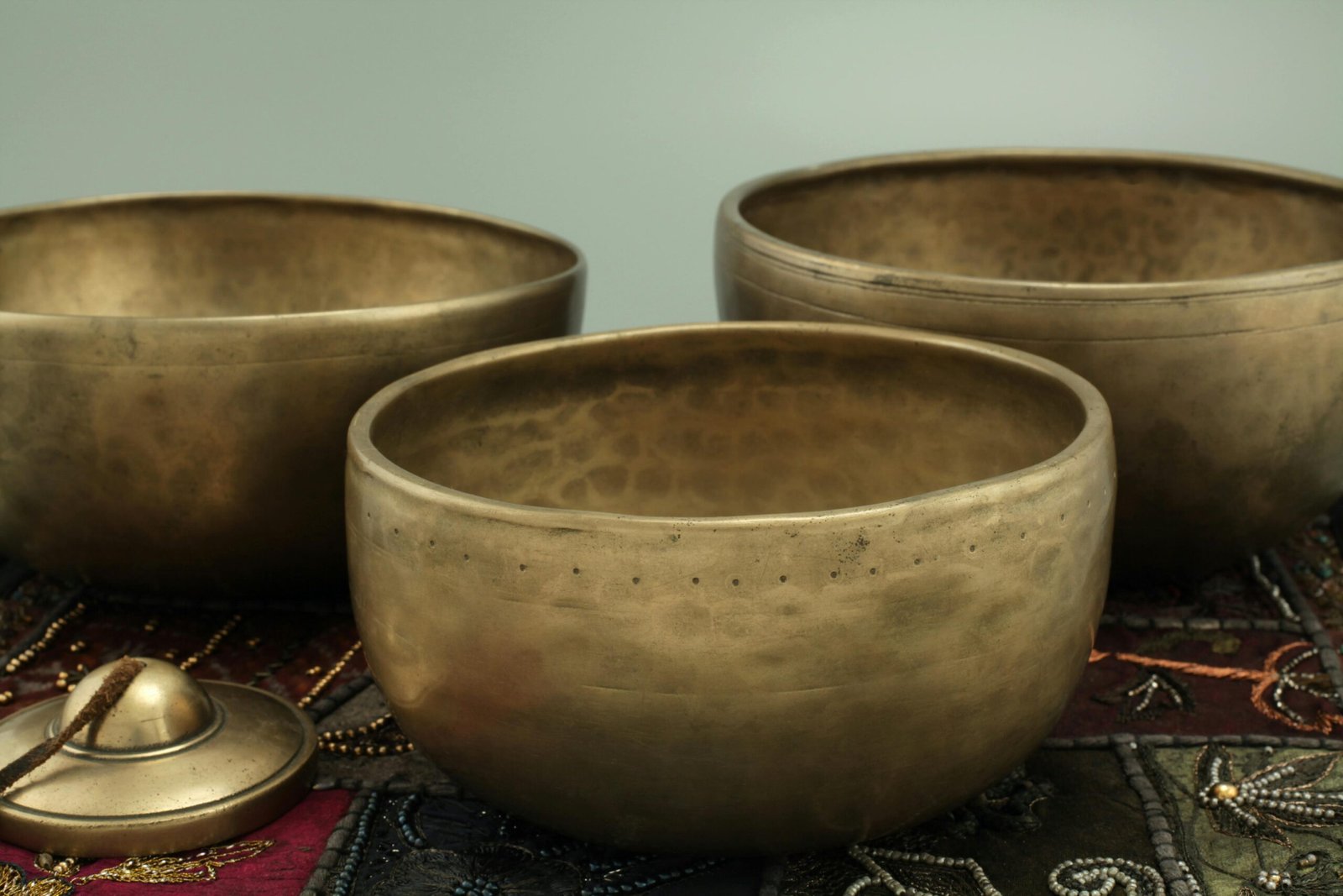 Elegant brass singing bowls on a decorative fabric background. Perfect for meditation and sound therapy.